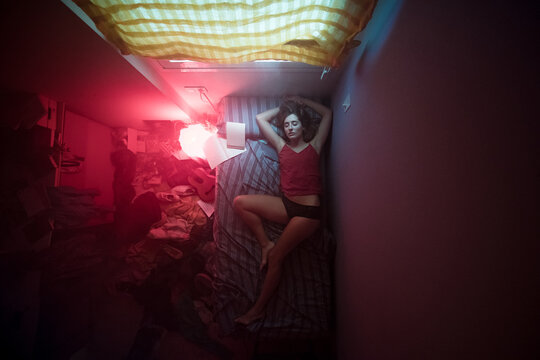 Sleeping woman in cinematic small dark bedroom