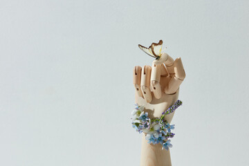 butterfly on wooden hand among white flower garden