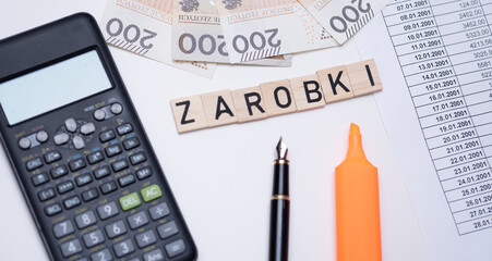 The inscription Zarobki which means earnings in Polish next to Polish money. Concept showing earnings in Poland.