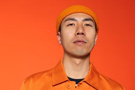 Stylish Man Against Orange Wall In Studio