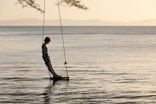 Boy on swing by lake