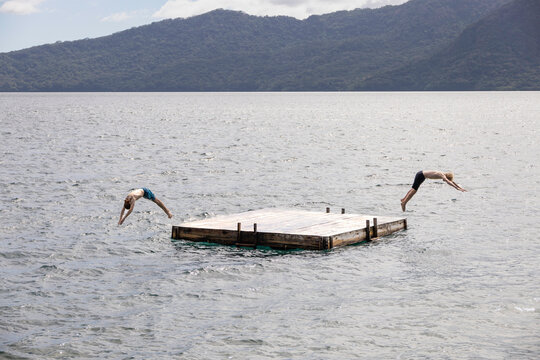 Boys diving into a lake