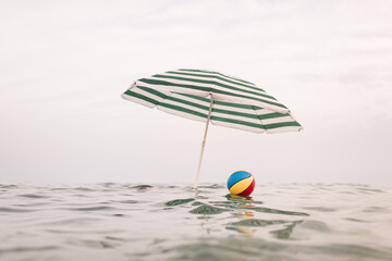 Fototapeta premium Surreal summer scenery with beach ball and umbrella