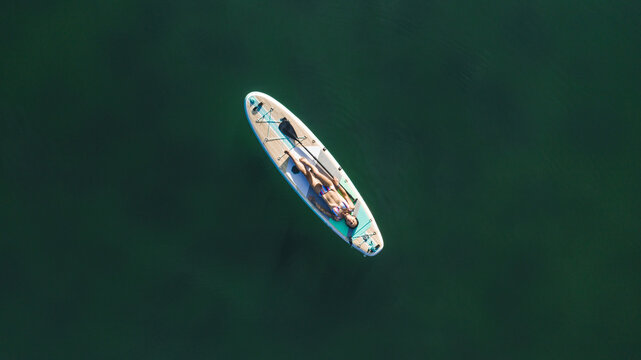 woman lying on paddle board