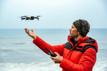 Obraz premium Male explorer operating drone near ocean