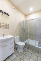 Bathroom in a small family hotel with shower, toilet and sink