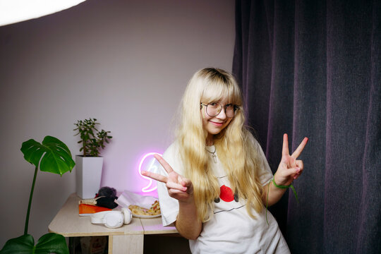 A teenager in his room takes a photo at night