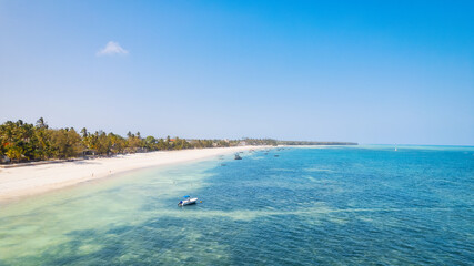 Escape to a tropical paradise with a picture-perfect beach featuring white sand, swaying palm trees, and crystal-clear turquoise waters against a blue sky with fluffy clouds on a sunny summer day. 
