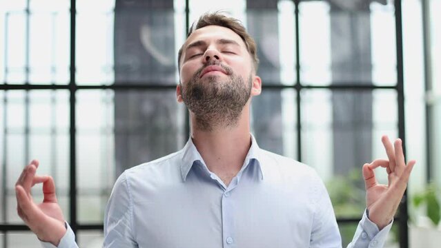 Young businessman relaxing while standing in the office