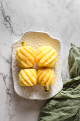 peeled small pineapple on a white plate