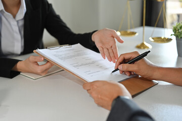 Cropped view of client signing contract or legal papers with lawyer. Law services concept.