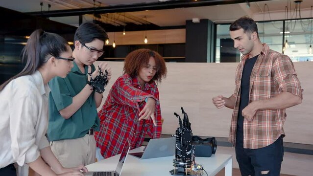 4K, male teacher is teaching students attending class, equip robot hand move robot hand, in order support weight robot hand, move robotic hand provided control robotic hand placed on table in front.