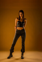 A full length photo of a brunette girl posing in black leather outfit