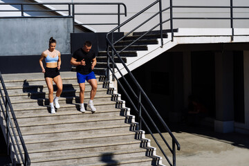 Fototapeta premium Sporty couple running on a stairs in the city