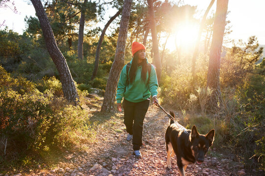 Woman walking in forest with dog