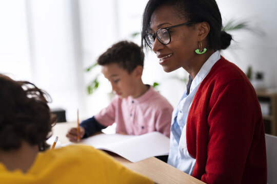 Black mother helping sons with homework