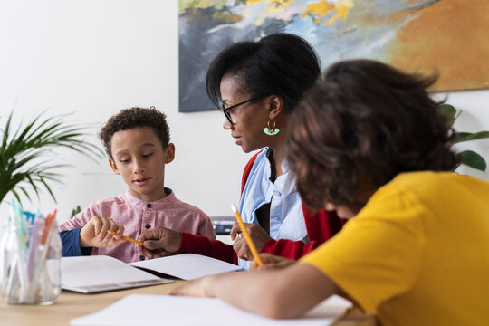 Black mother helping sons with homework