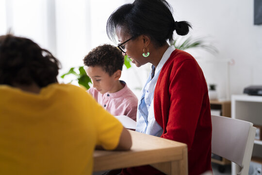 Black mother helping sons with homework