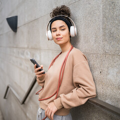 One young sporty woman with headphones use mobile phone app for music