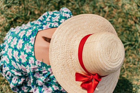 Little girl with sun hat and flowers dress. Spring portrait