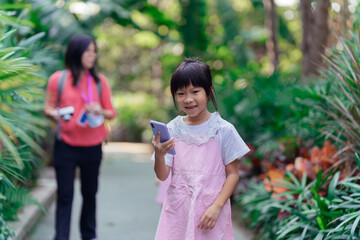 Little girl uses mobile phone navigation on the street