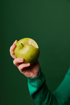Crop woman holding green apple