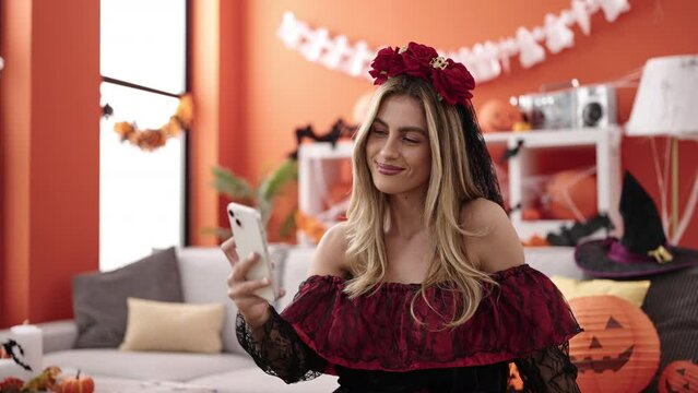 Young blonde woman making selfie by smartphone having halloween party at home