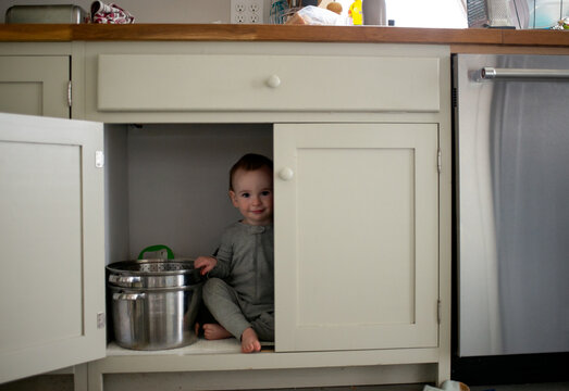 Cute Toddler Hiding Inside Kitchen Cupboard