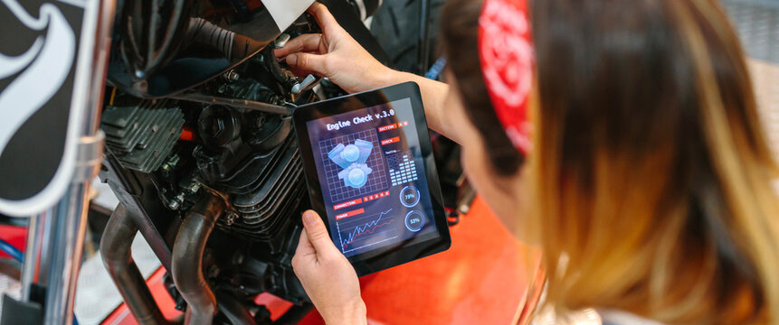 Mechanic woman using engine diagnosis app to review motorcycle
