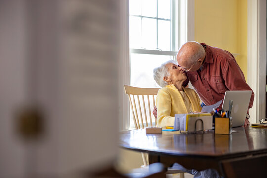 Senior Citizen kiss at Home Paying bills family together with love