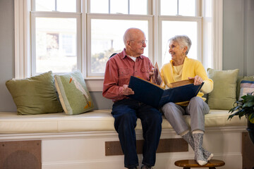 Senior Citizen couple at home Looking at family photo album 