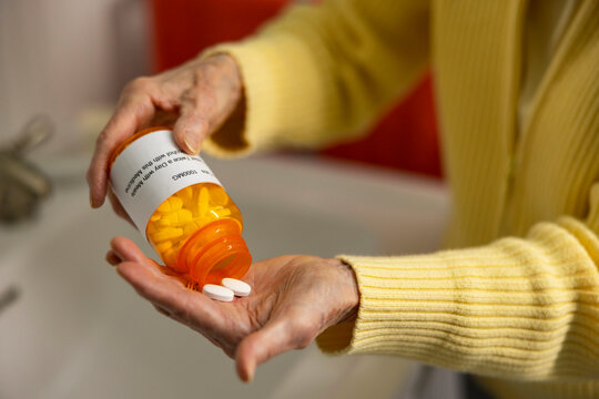 Retired Senior hand  with prescription pill drug medication 