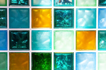 Wall made of square glass tiles. Background of glass cubes