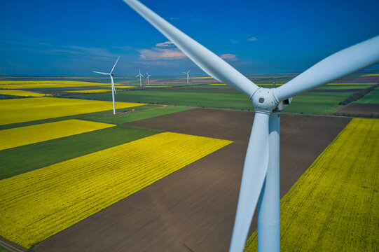 Aerial drone view of wind mills rotating by the force of the wind and generating renewable energy. Renewable alternative energy sources.