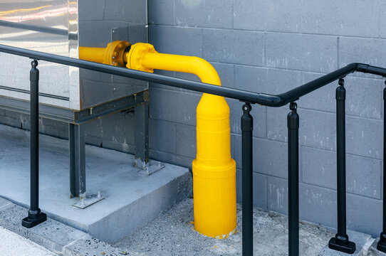 A fire hydrant with a yellow pipe connected to it.