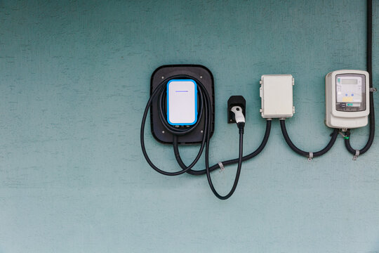 Electric car charger installed on a building wall.