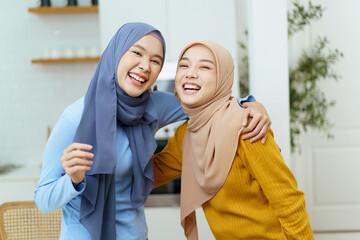 Happy cheerful Asian muslim women friend waving a hands and smiling to camera. Asian young muslim women colleague in relax lifestyle.