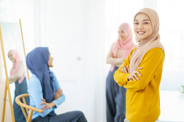 Happy Asian muslim businesswomen having a discussion together in office, modern muslim society and working environment concept. Asian Muslim women friends talking together.