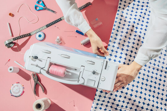 Tailor threading needle on machine 
