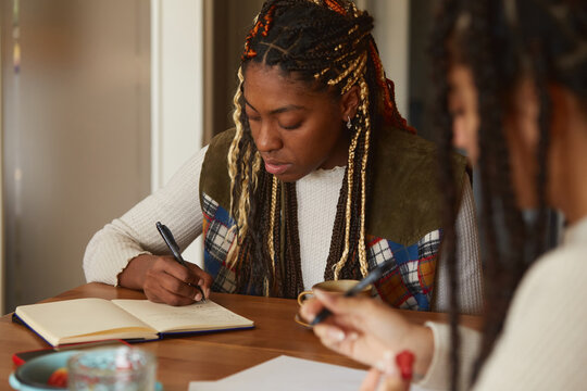 Friends studying and writing in a notebook