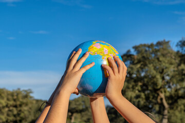 Earth Conservation Concept. 2 Children Embracing The Globe With Their Hands.