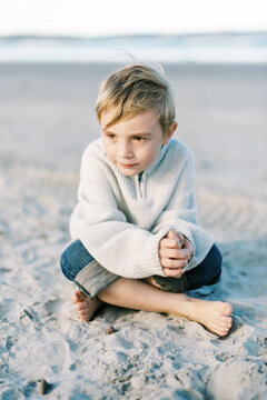 Little boy in knit swear and jeans at an east coast beach 