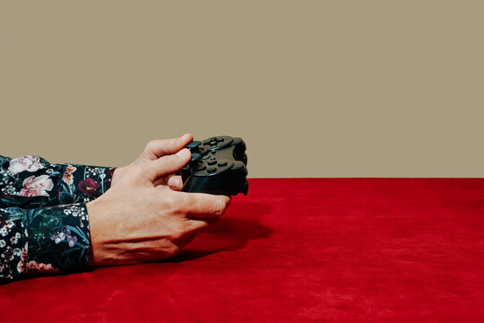 man using a game controller sitting at a table
