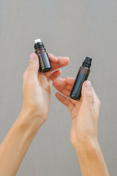 A woman's hand holds a blend roller with natural facial oil