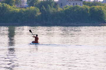 Active recreation on the board on the big river. Tourism on sap boards. Outdoor water sports. A man...