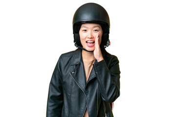 Young Asian woman with a motorcycle helmet over isolated chroma key background shouting with mouth wide open