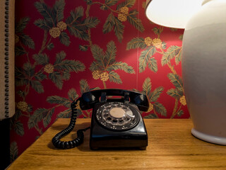Vintage black Rotary Dial Telephone and funky wallpaper 