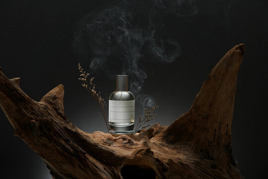 Perfume container on the podium made of tree bark on a dark background
