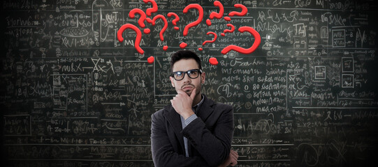 pensive man with math problems on the blackboard