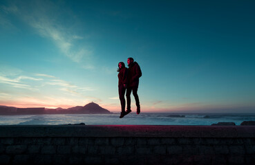 Surreal portrait of couple floating in the air at sunset